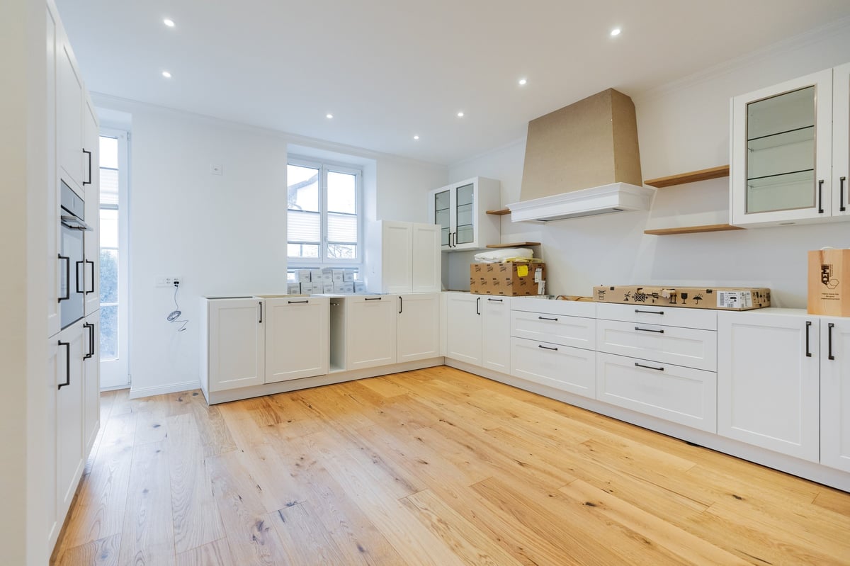 Modern kitchen with white cabinetry, wooden countertops, stainless steel appliances, and light wood flooring