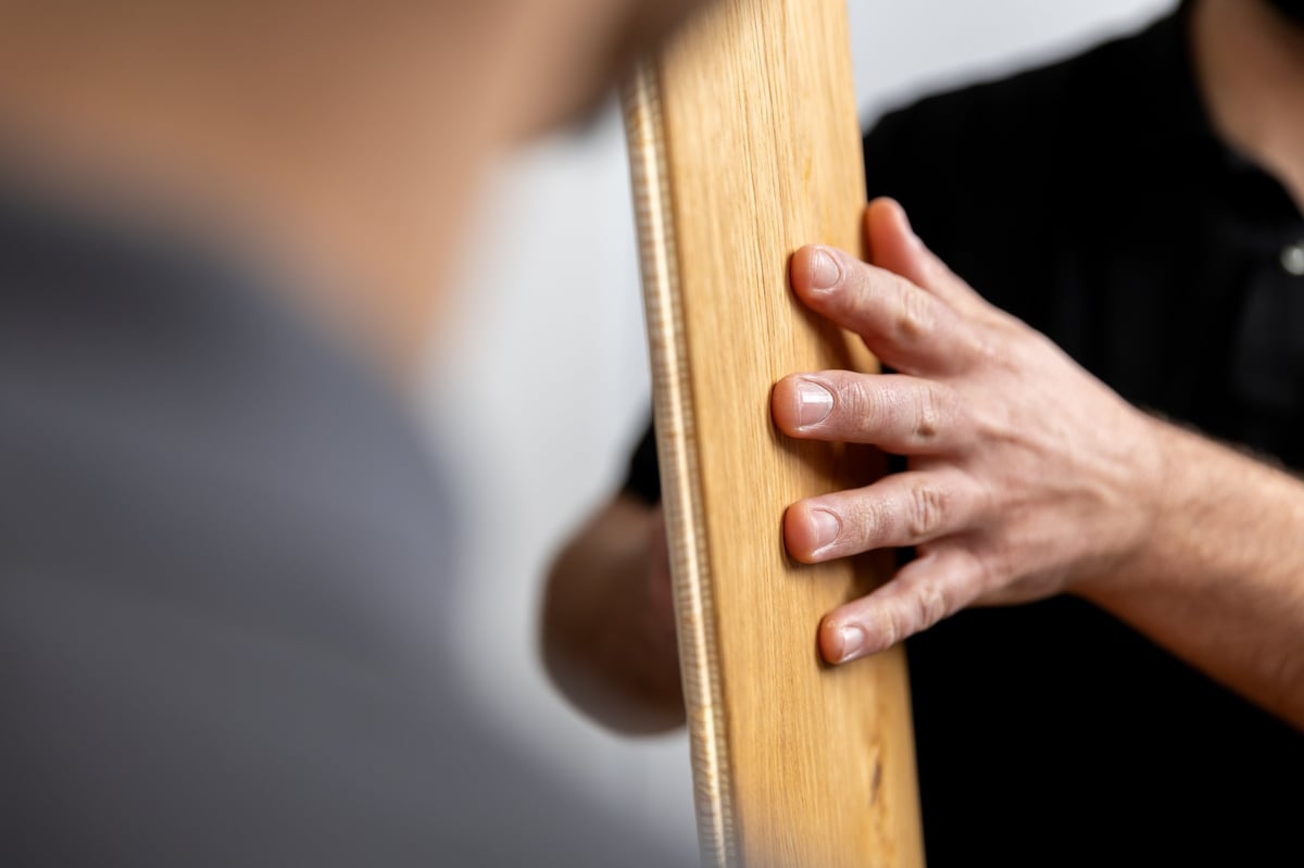 Close-up of a hand touching a wooden surface with rope detail